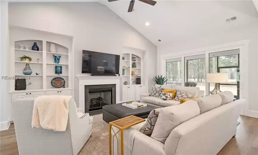 Gas fireplace is flanked by built-in shelves and slider opens room to screen porch