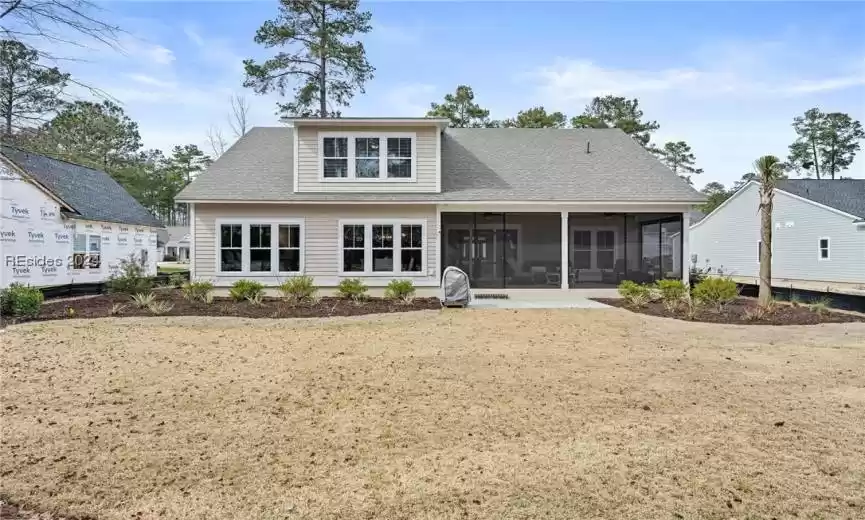 Back of home showing large screen porch and patio