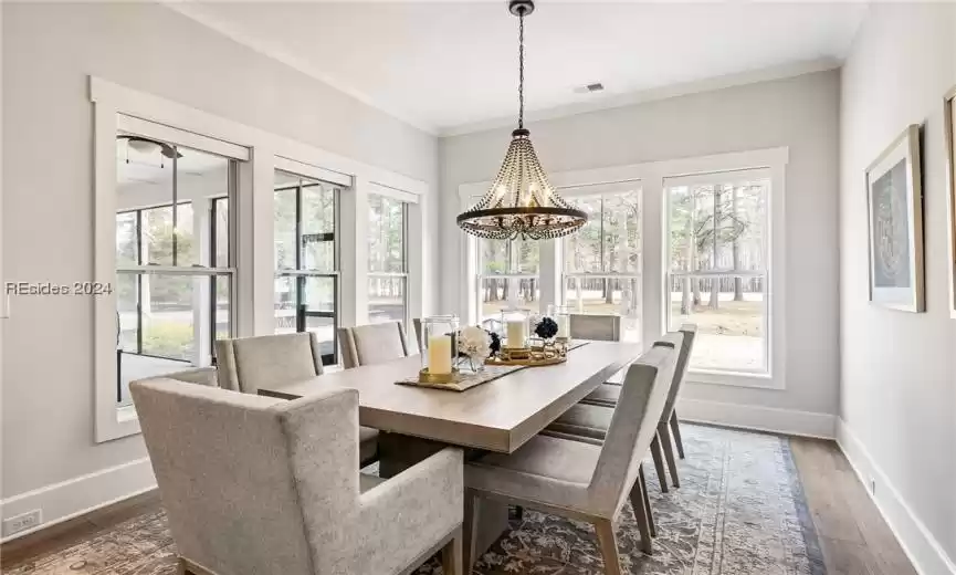 Dining area with stunning light fixture and roller shades
