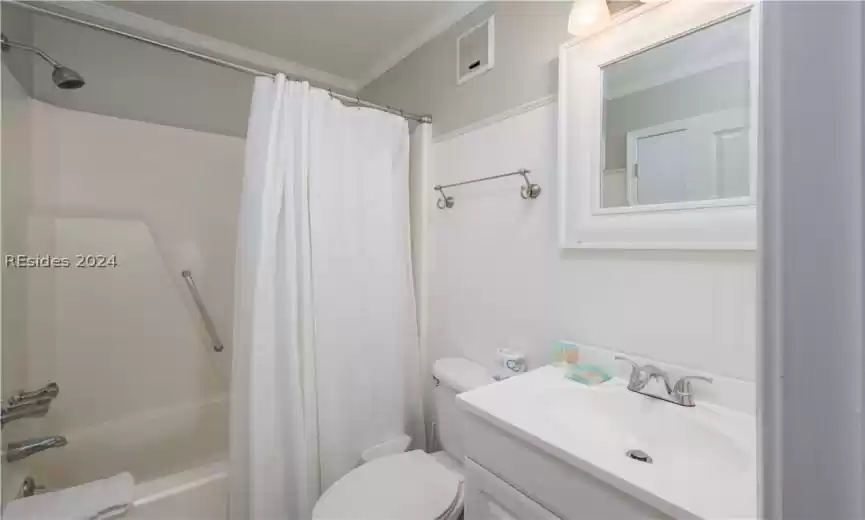 Full bathroom featuring ornamental molding, oversized vanity, shower / bath combination with curtain, and toilet