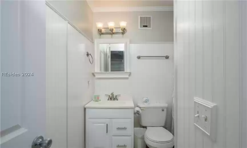 Bathroom with vanity, toilet, and crown molding