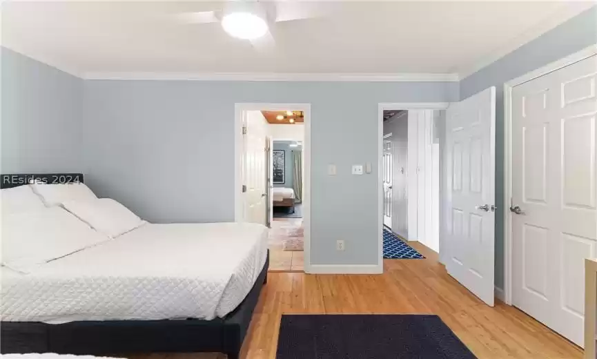 Bedroom featuring ornamental molding, light wood-type flooring, and ceiling fan
