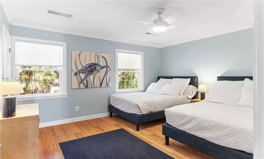 Bedroom featuring light wood-type flooring, crown molding, and ceiling fan