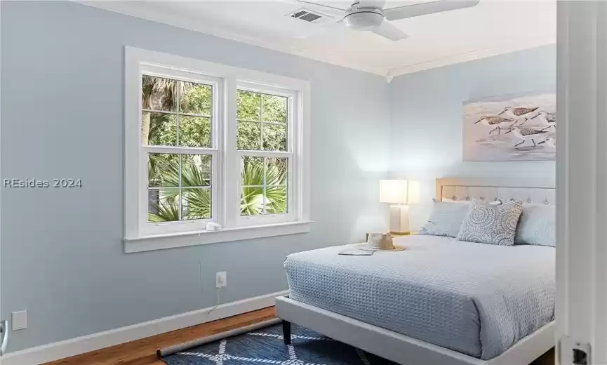 Bedroom with dark hardwood / wood-style flooring, ornamental molding, and ceiling​​‌​​​​‌​​‌‌​‌‌​​​‌‌​‌​‌​‌​​​‌​​ fan
