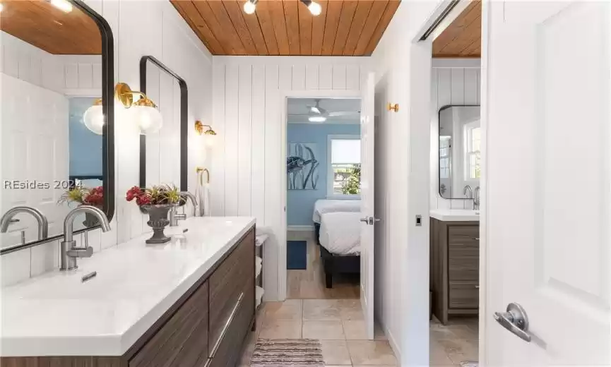 Bathroom with ceiling fan, vanity with extensive cabinet space, and wooden ceiling