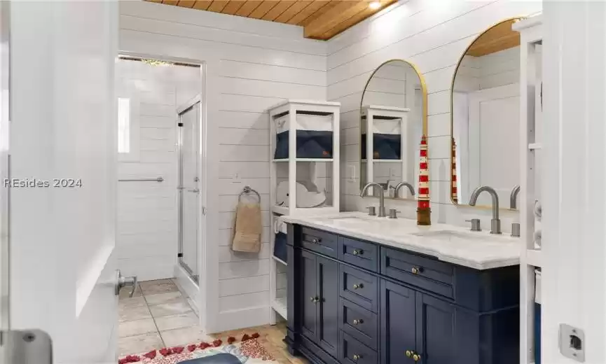 Bathroom with double sink, wooden ceiling, tile floors, walk in shower, and large vanity