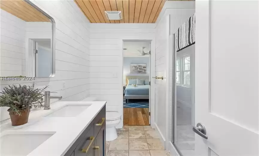 Bathroom featuring dual bowl vanity, toilet, tile flooring, wooden ceiling, and ceiling fan