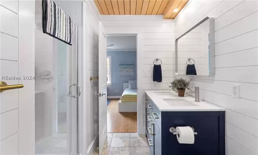 Bathroom featuring vanity, hardwood / wood-style floors, a shower with door, wooden ceiling, and crown molding
