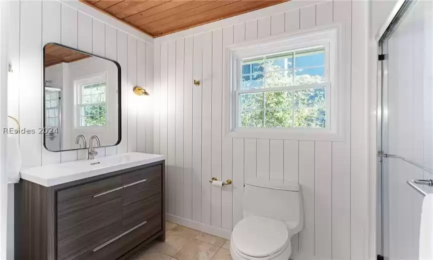 Bathroom with vanity, toilet, tile flooring, wooden ceiling, and walk in shower