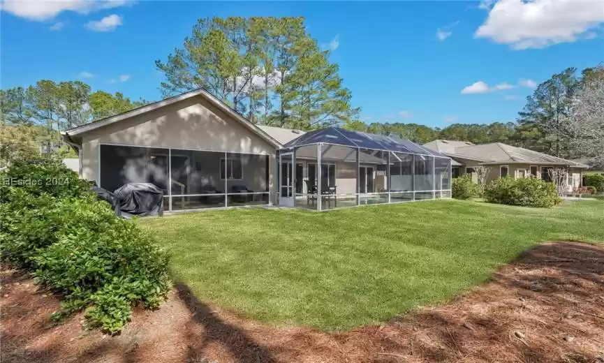 Beautiful backyard with view of the pool, lagoon and woods.
