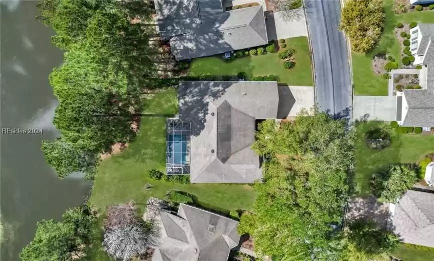 Aerial view showing backyard oasis of a pool, lagoon and wooded view