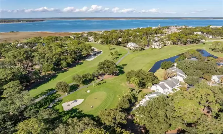 Aerial view of Twin Oaks Villas, 10th Fairway and Green, 16th Fairway of Harbour Town Golf Links with Harbour Town Marina and Calibogue Sound in the distance.