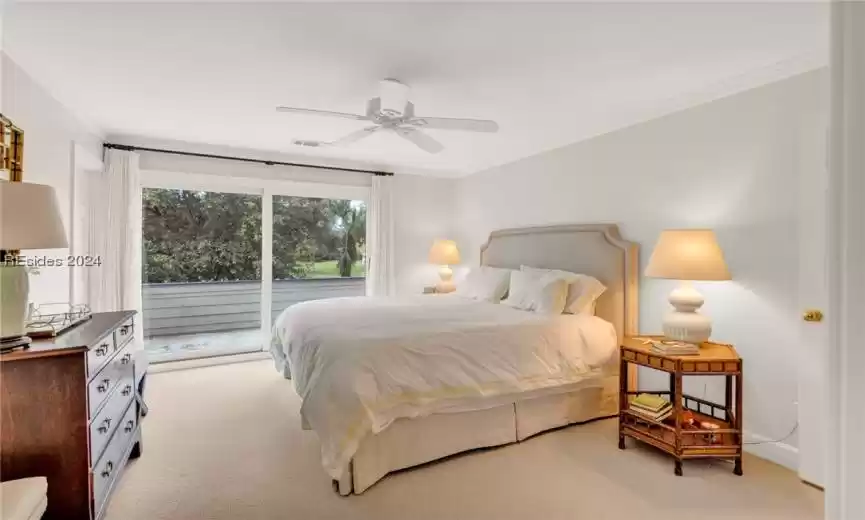 Carpeted bedroom featuring access to exterior, ceiling fan, and ornamental molding