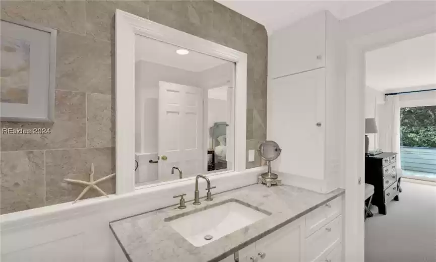 Bathroom with vanity, crown molding, tile walls, and radiator heating unit