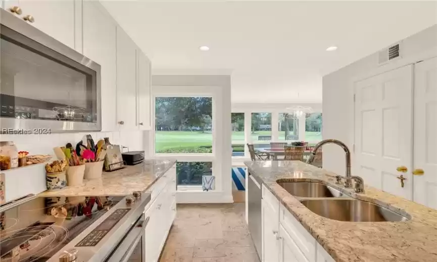 Kitchen featuring white cabinetry, a wealth of natural light, appliances with stainless steel finishes, and backsplash
