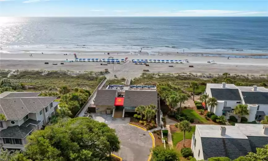 Birds eye view of property with a view of the beach and a water view