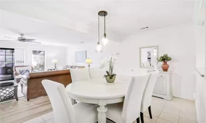 Dining space with light wood-type flooring, crown molding, and ceiling fan