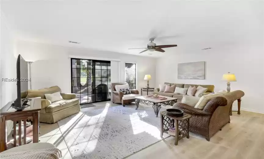 Living room featuring light hardwood / wood-style floors, crown molding, and ceiling fan