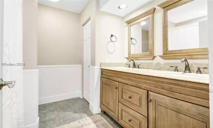 primary Bathroom with dual bowl vanity and tile flooring