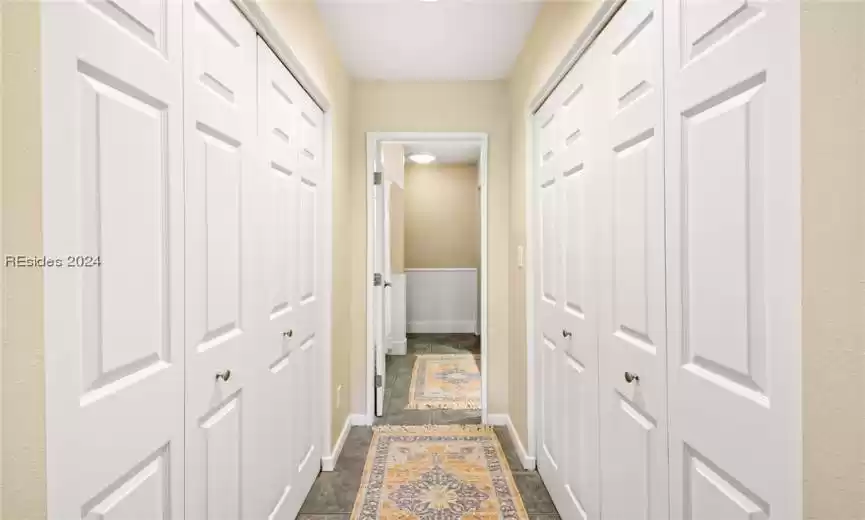 Primary hallway featuring flanking closets and tile flooring