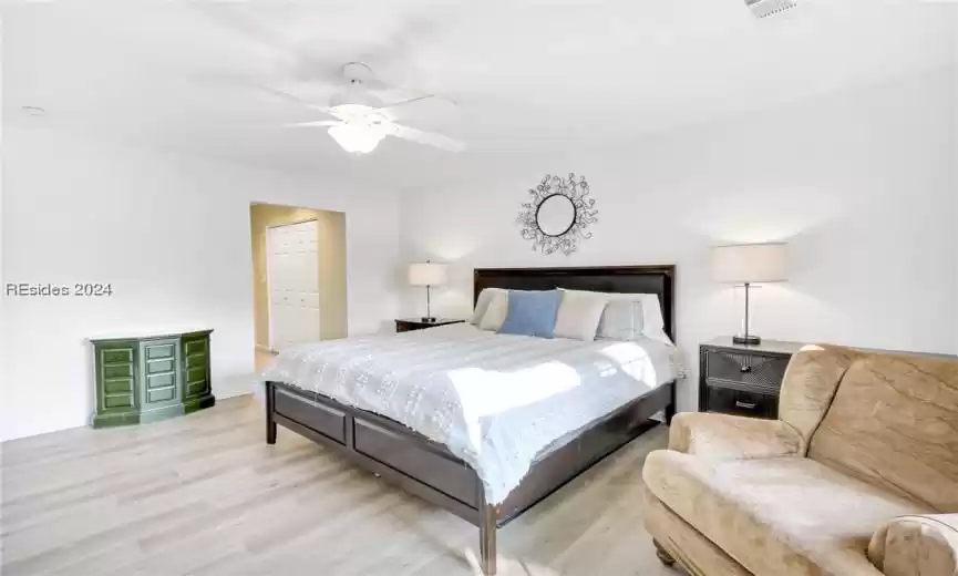 Bedroom with light hardwood / wood-style flooring, a closet, and ceiling fan