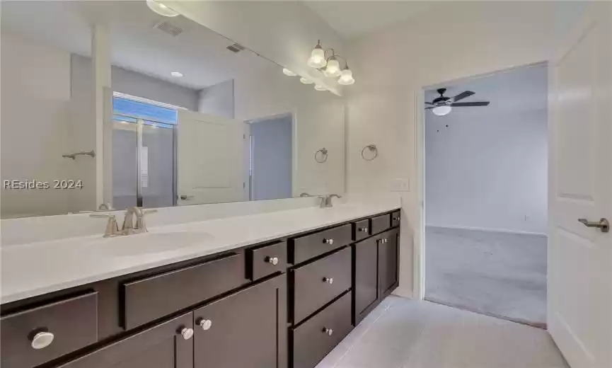 Primary bathroom with double vanity, tile flooring