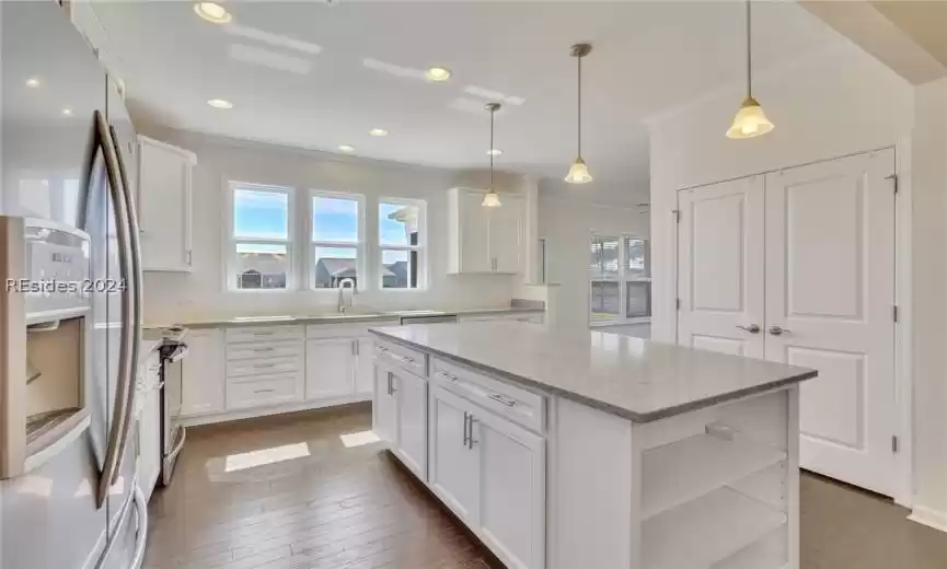 Kitchen featuring a wealth of natural light, appliances with stainless steel, dark hardwood / wood-style flooring, and a kitchen island
