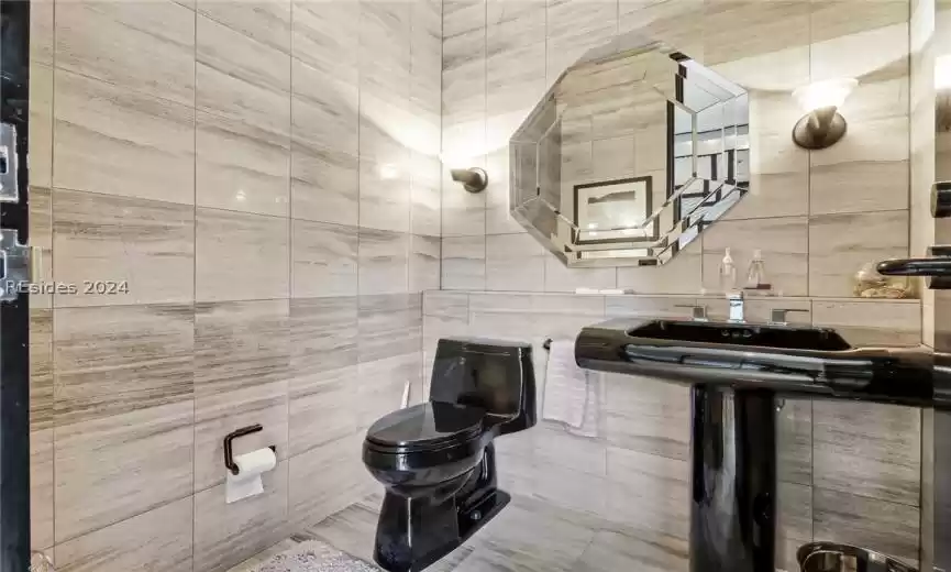 Bathroom with tile walls and toilet