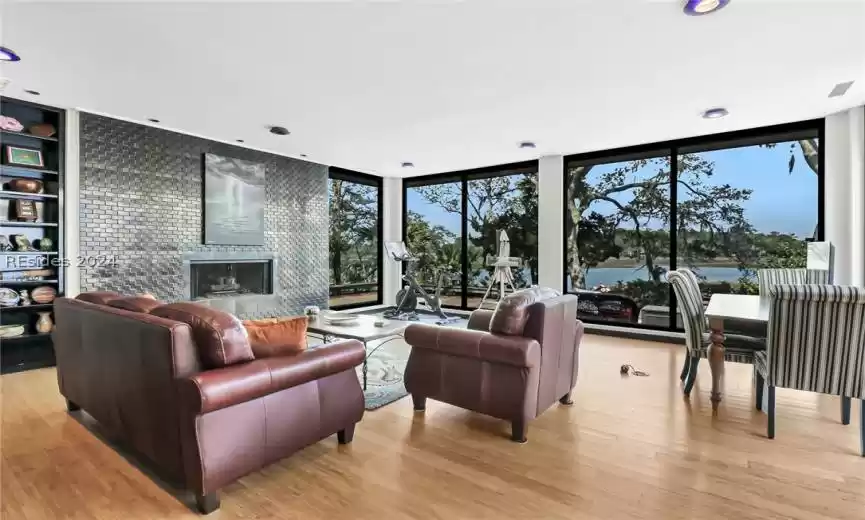 Living room with floor to ceiling windows and light wood-type flooring