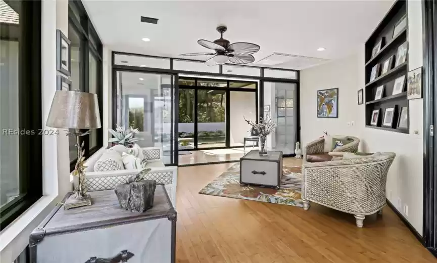 Living room featuring floor to ceiling windows, light hardwood / wood-style floors, and ceiling fan