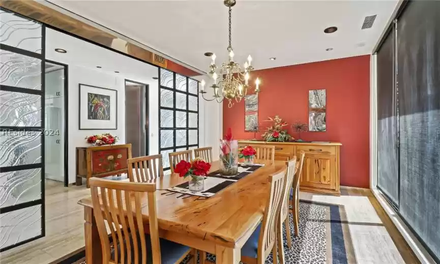 Dining area with light wood-type flooring and a chandelier