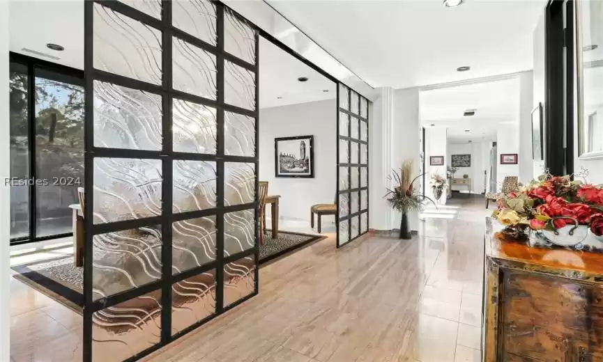 Corridor featuring light tile floors and a wall of windows