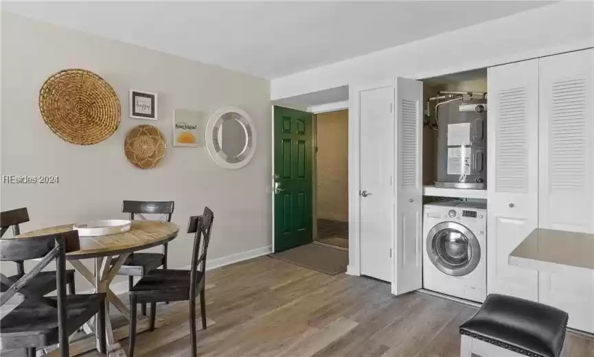 Laundry area featuring dark hardwood / wood-style floors, water heater, and washer / clothes dryer
