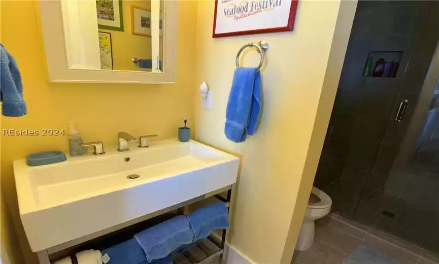 Bathroom with walk in shower with tile to ceiling.