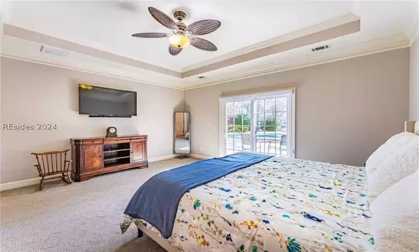 Carpeted bedroom with a tray ceiling, access to outside, ceiling fan, and crown molding