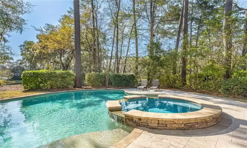 View of swimming pool featuring a patio and an in ground hot tub