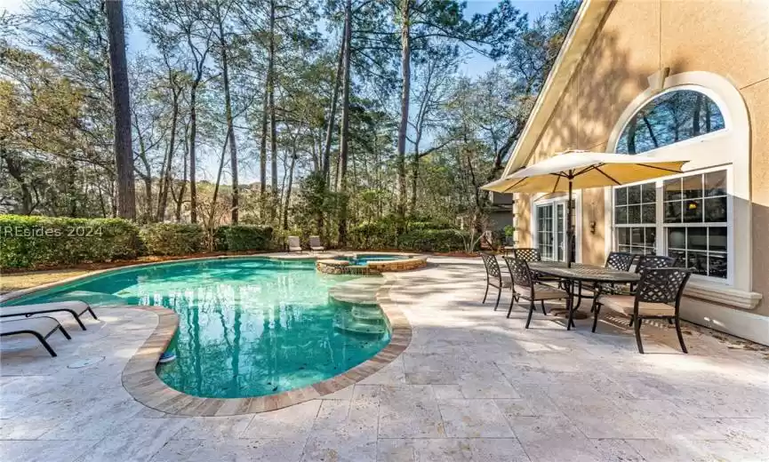 View of pool with a patio and an in ground hot tub