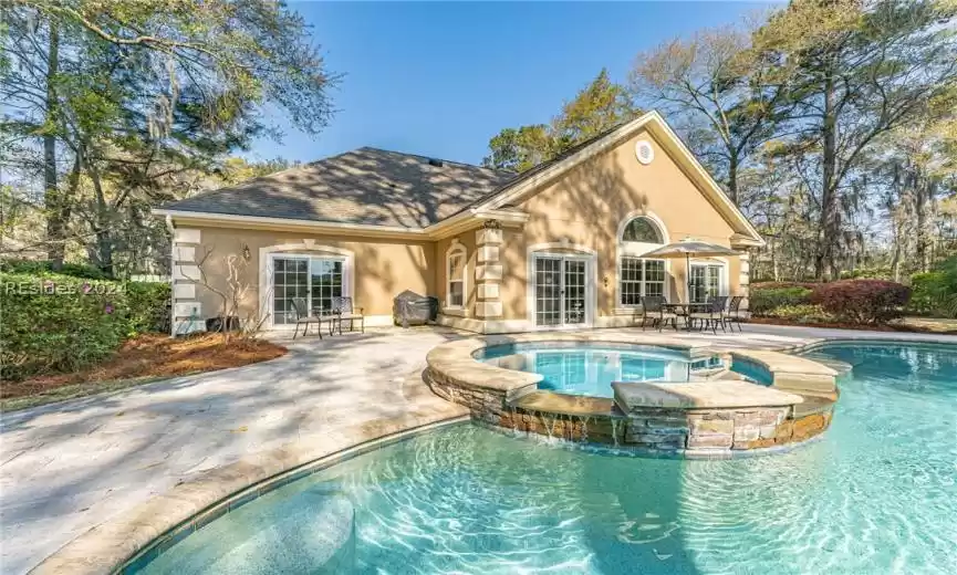View of swimming pool featuring french doors, an in ground hot tub, and a patio area