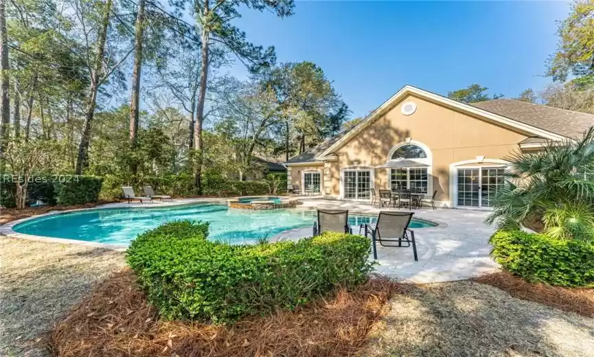 View of pool with a patio area and an in ground hot tub