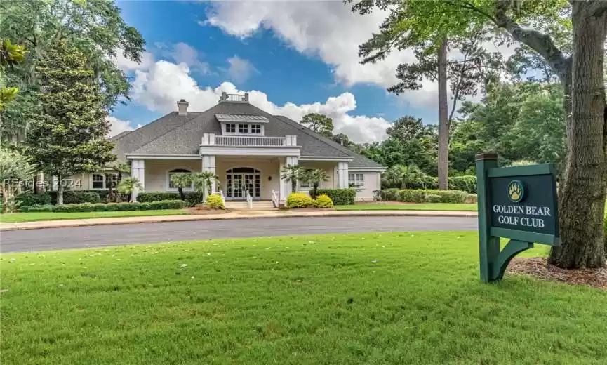Community / neighborhood sign featuring a yard