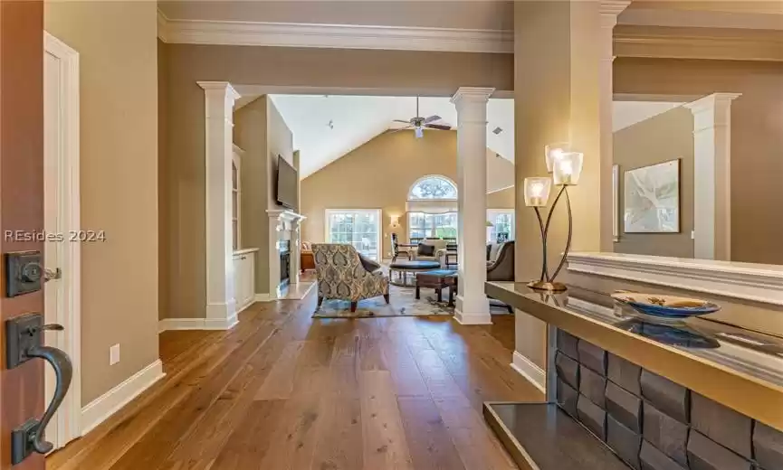 Entryway featuring hardwood / wood flooring, lofted ceiling, ceiling fan, and ornate columns