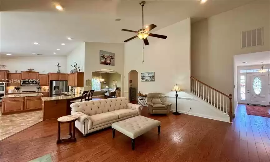 Living room with high vaulted ceiling, sink, a healthy amount of sunlight, and ceiling fan