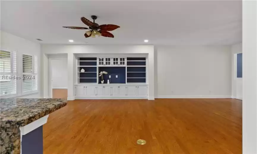Spare room featuring built in features, light hardwood / wood-style floors, and ceiling fan