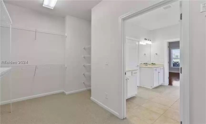 Walk in closet featuring light tile flooring