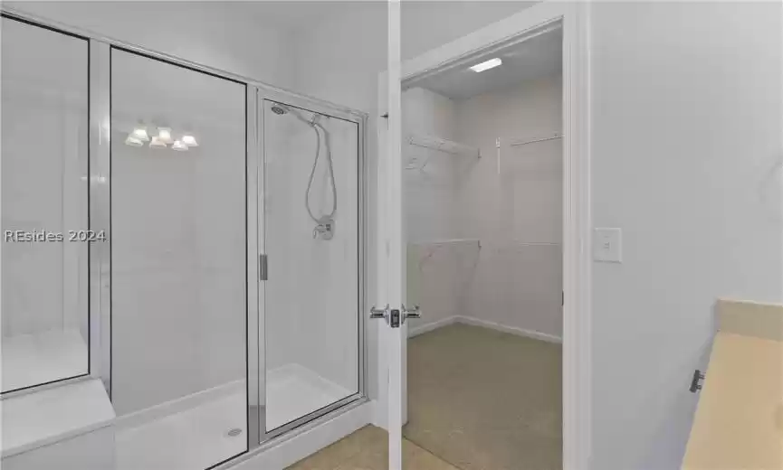 Bathroom with vanity, walk in shower, and tile floors