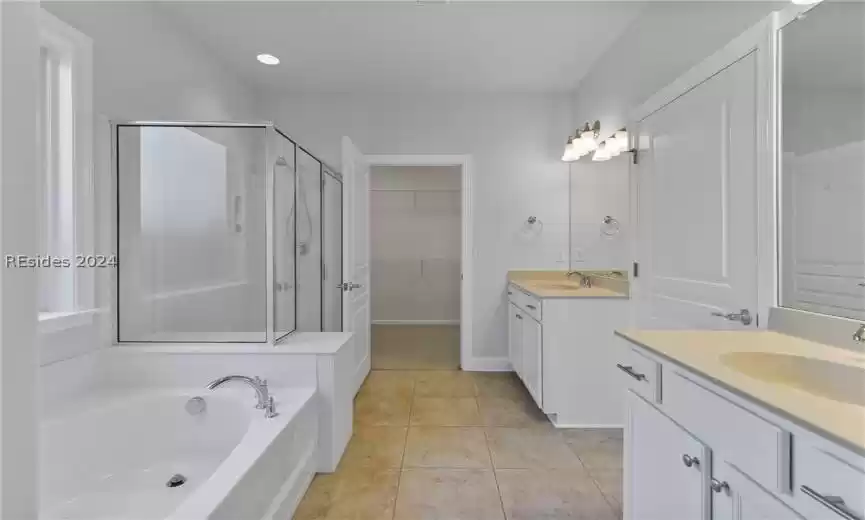 Bathroom featuring independent shower and bath, tile floors, large vanity, and dual sinks