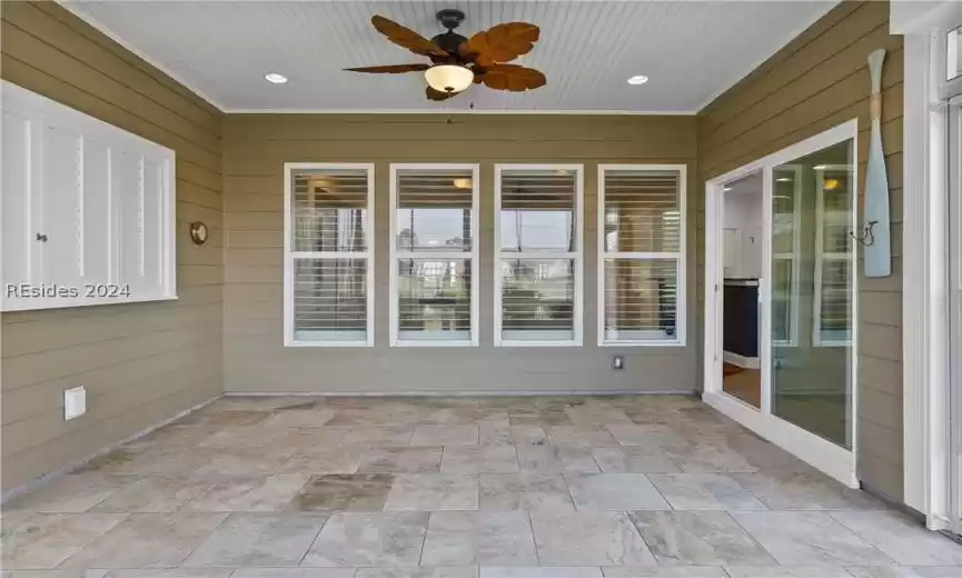 Unfurnished sunroom featuring ceiling fan
