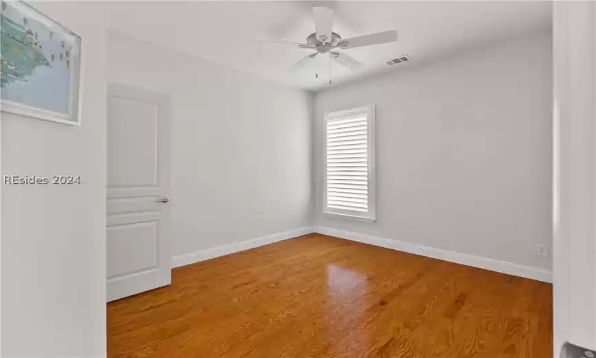 Empty room featuring light wood-type flooring and ceiling fan