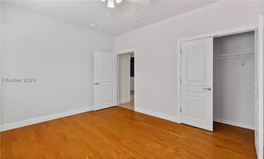 Unfurnished bedroom with a closet, light hardwood / wood-style floors, and ceiling fan