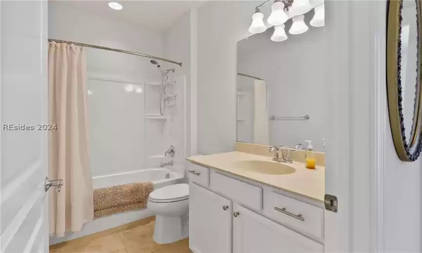Full bathroom featuring tile floors, shower / bath combination with curtain, toilet, and oversized vanity
